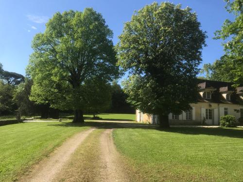 une maison avec deux arbres devant un chemin de terre dans l'établissement la Chartreuse maison d artistes, à Bergerac