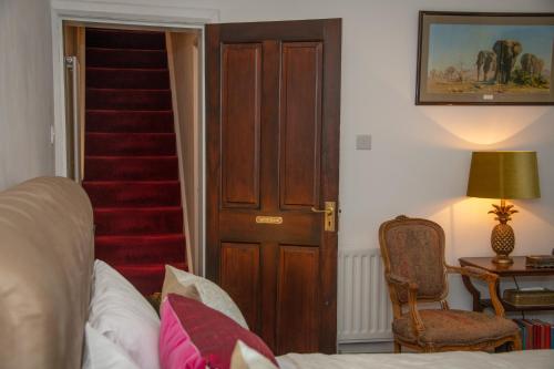 a room with a door and a staircase with a chair at Stay@27 in Brighton & Hove