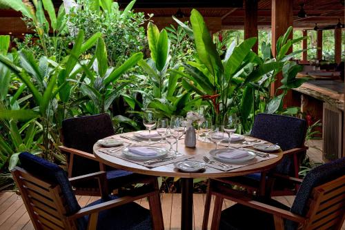 a wooden table with plates and wine glasses at Hotel Fasano Trancoso in Trancoso
