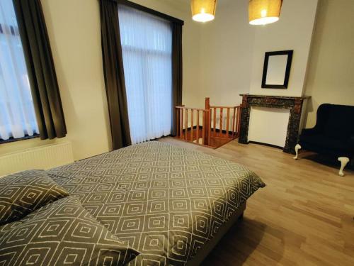 a bedroom with a bed and a chair and a fireplace at Modern duplex 100m2 perfect to visit Brussels in Brussels