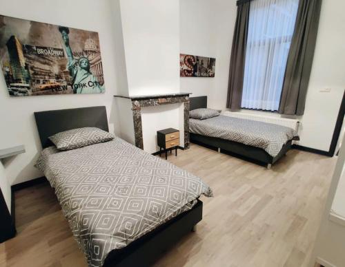 een slaapkamer met 2 bedden en een open haard bij Modern duplex 100m2 perfect to visit Brussels in Brussel