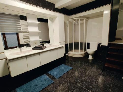 y baño con 2 lavabos, ducha y aseo. en Modern duplex 100m2 perfect to visit Brussels, en Bruselas