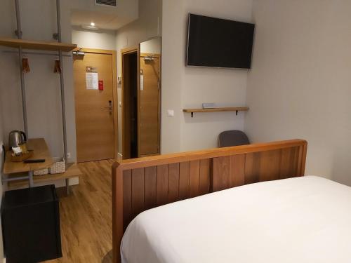 a bedroom with a bed and a television on the wall at Habital Suites in Jaca