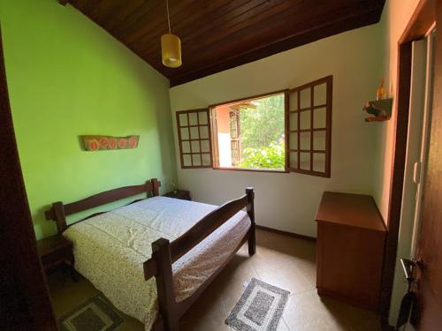 卢米亚Lumiar chalé colonial lareira deck para beira rio particular e reservado área de lazer pertinho centro do bairro的一间卧室，里面有一张床和一扇窗户。