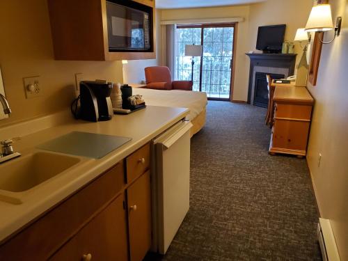 a hotel room with a kitchen and a bed at Homestead Suites - Fish Creek in Fish Creek