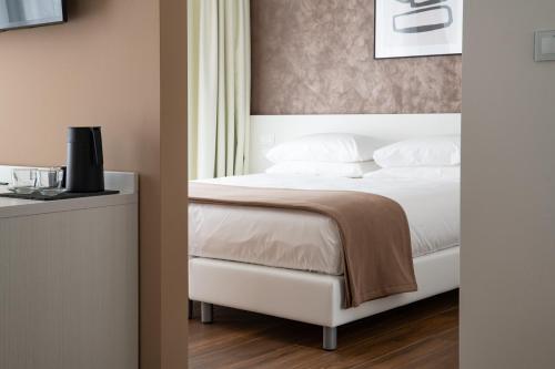 a bedroom with a bed with white sheets and pillows at Arca Guest House in San Trovaso