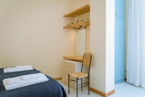 a small bedroom with a bed and a chair at Vento Verde Apartments in Sperlonga