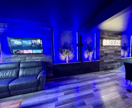 a living room with a couch and blue lighting at BREEZE SUITES - LUXURY GROUP ACCOM - SLEEPS 19 in Blackpool