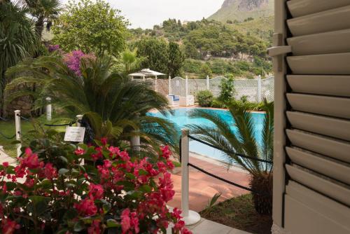 a view of a swimming pool from a house with flowers at Vento Verde Apartments in Sperlonga