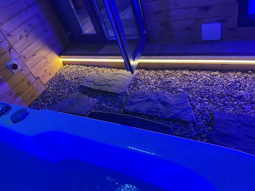 - une baignoire dans une chambre avec des pierres et des lumières dans l'établissement BREEZE SUITES - LUXURY GROUP ACCOM - SLEEPS 19, à Blackpool