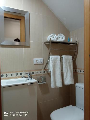 a bathroom with a toilet and a sink and towels at LOFT ALQUILER ALCALALÍ in Alcalalí