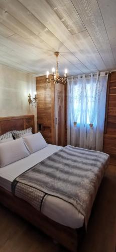 - une chambre avec un grand lit et un lustre dans l'établissement Le Renne Blanc Pyrénées de France, à Font-Romeu
