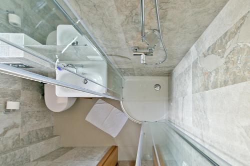 a glass staircase in a bathroom with a sink at Palanga Visit Apartments and SPA in Palanga
