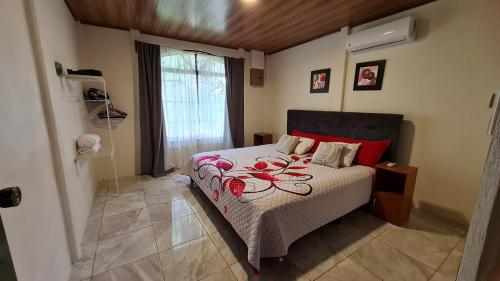 ein Schlafzimmer mit einem Bett mit roten Kissen in der Unterkunft Casa Arboleda-Full House by the River and Forest and Gardens in San Francisco