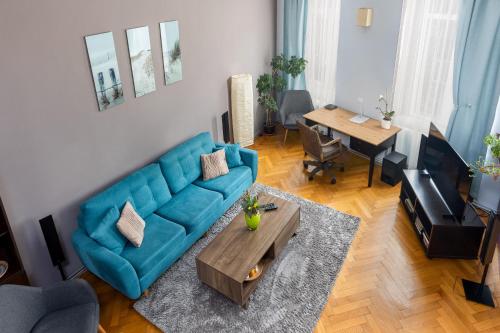 a living room with a blue couch and a table at Stylish Studio Kronstadt in Braşov