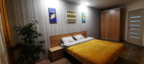 ein Schlafzimmer mit einem Bett mit einer gelben Decke in der Unterkunft New clean apartments in Winnyzja