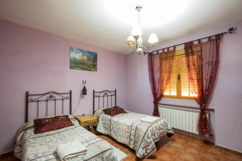 a bedroom with two beds and a window at El Robledillo in Robledillo