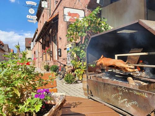 a pig is cooking on a grill on a street at Gasthaus & Hotel Drei Lilien in Werbach