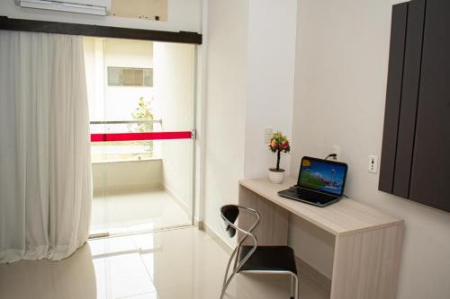 a laptop computer sitting on a desk next to a window at Hotel BHS in Linhares