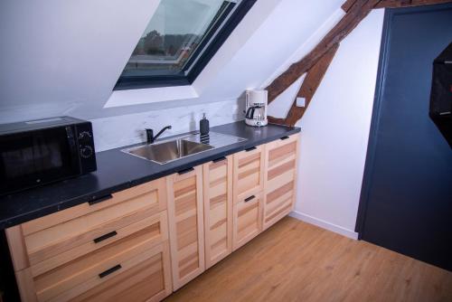 a kitchen with a sink and a microwave at L'Atelier Brainois - Meublé de tourisme 3*** in Braine