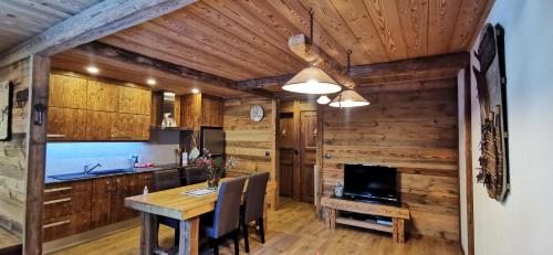 a kitchen with a dining room table and a television at Le Renne Blanc Pyrénées de France in Font-Romeu