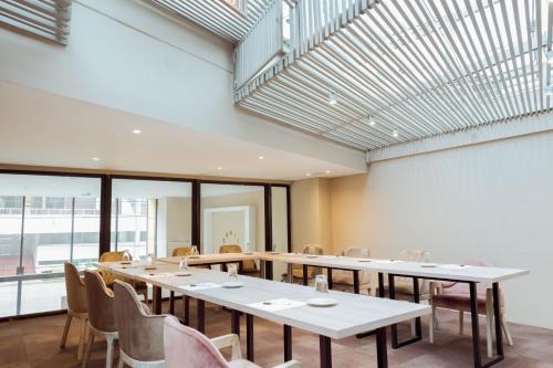 a dining room with tables and chairs and windows at Hotel City Bog Corferias in Bogotá