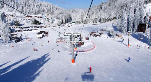 a group of people on a ski lift in the snow at Apartman Nela 2 Jahorina in Jahorina