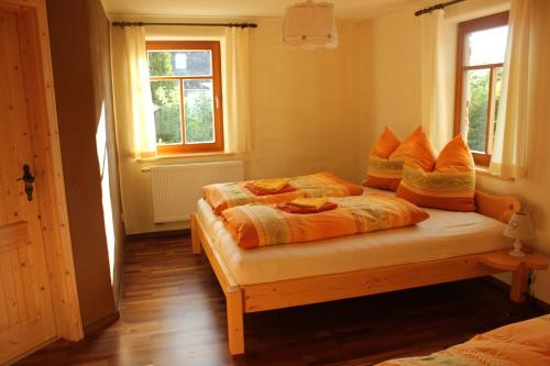 a bedroom with two beds and two windows at Pension 'Am Vogelherd' in Schleiz