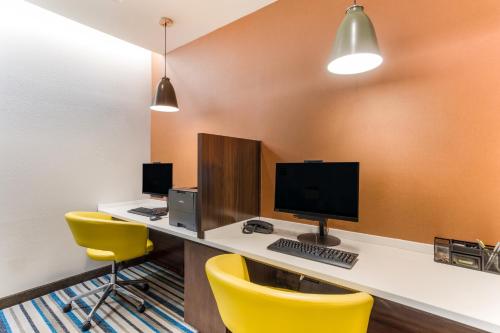 an office with a desk with a computer and yellow chairs at MainStay Suites Murfreesboro in Murfreesboro