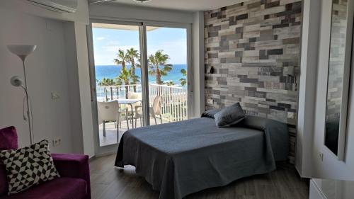 - une chambre avec un lit et un balcon donnant sur l'océan dans l'établissement Estudio FARO TORROX-1ª línea playa, à Torrox Costa