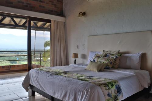 a bedroom with a bed with a view of the ocean at Hotel Tata Premium in Pueblo Tapao