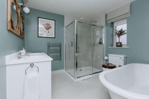 een badkamer met een douche, een bad en een wastafel bij Hayward House, Hot Tub, Large Garden in Henley on Thames