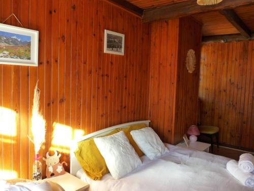 a bedroom with a bed in a wooden wall at L'ânon d'Andon in Andon