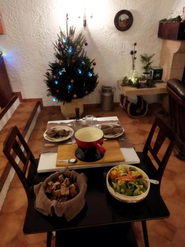 a table with food and a christmas tree in a room at L'ânon d'Andon in Andon