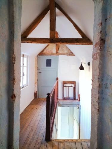 an attic room with a wooden floor and a staircase at Maison Séraphine - Guest house - Bed and Breakfast in Laon