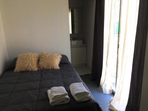 盧漢德庫約的住宿－Chacras Coria Posada 1460，一间卧室配有一张床,上面有两条毛巾