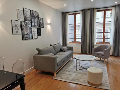 een woonkamer met een bank en een tafel bij Ô Cœur de Troyes - Bulles & Spa 4 étoiles in Troyes