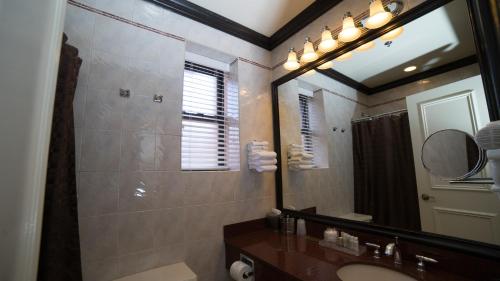 a bathroom with a sink, mirror, and toilet at Hotel Lucerne in New York