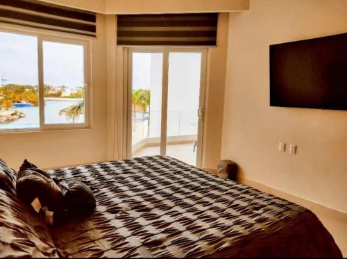 Bliss at Puerto Aventuras في بويرتو أفينتوراس: غرفة نوم بسرير ونافذة كبيرة