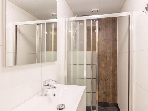 een witte badkamer met een wastafel en een douche bij Nice group accommodation with BBQ in Overijssel in De Bult