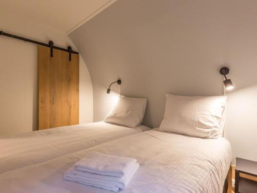 een slaapkamer met een bed met twee handdoeken erop bij Nice group accommodation with BBQ in Overijssel in De Bult