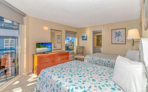 een slaapkamer met 2 bedden en een flatscreen-tv bij Oceanfront 1 Bedroom 2 Bath Suite Boardwalk 439 in Myrtle Beach