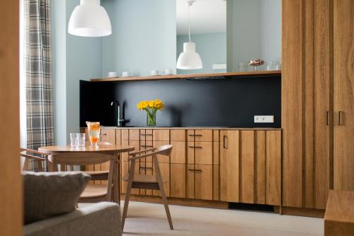 a dining room with a table and a tv at Palanga Visit Apartments and SPA in Palanga