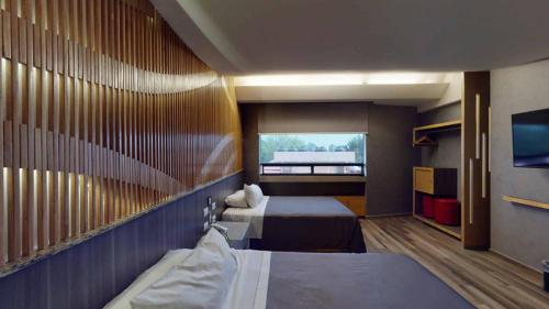 a hotel room with two beds and a tv at Hotel Patriotismo in Mexico City