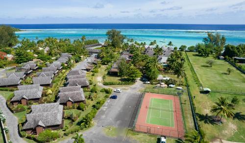 an aerial view of a resort with a tennis court and the ocean at Moorea Sunset Beach in Haapiti