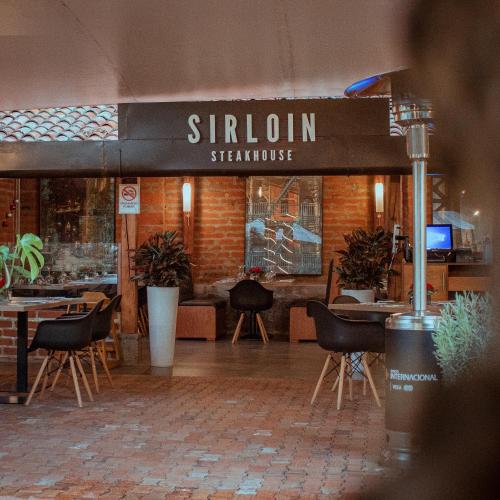 a restaurant with chairs and tables and a sign that reads stationknife at Rukka Lodge in Tumbaco