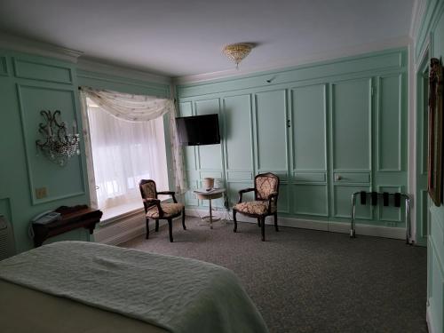 a bedroom with a bed and a table and chairs at Lowell Inn in Stillwater