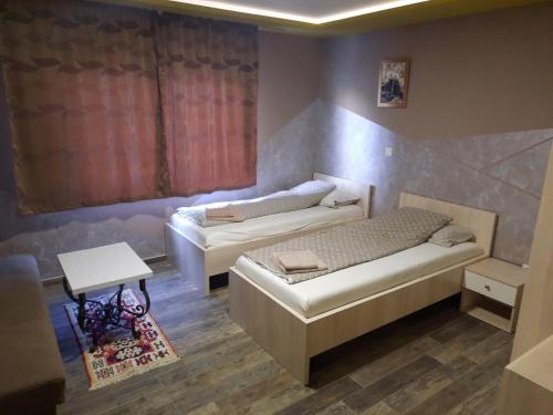 um quarto com duas camas e uma mesa em Apartments "Our Place" Sarajevo em Ilidža