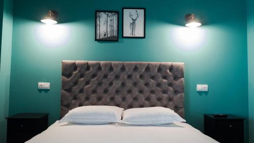 ein Schlafzimmer mit einem Bett mit zwei Kissen und zwei Lichtern in der Unterkunft Villa Wild Rooms in Jieţ
