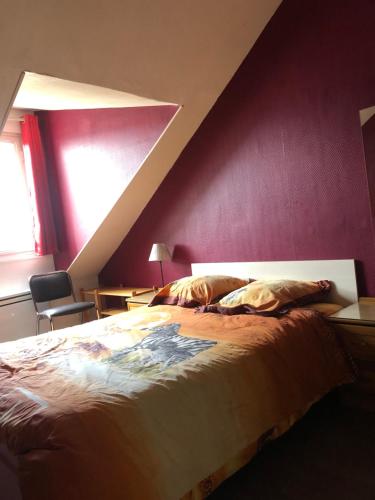 - une chambre avec un grand lit et un mur pourpre dans l'établissement DUPLEX F3 - CENTRE ROUEN - 5 Lits, à Rouen